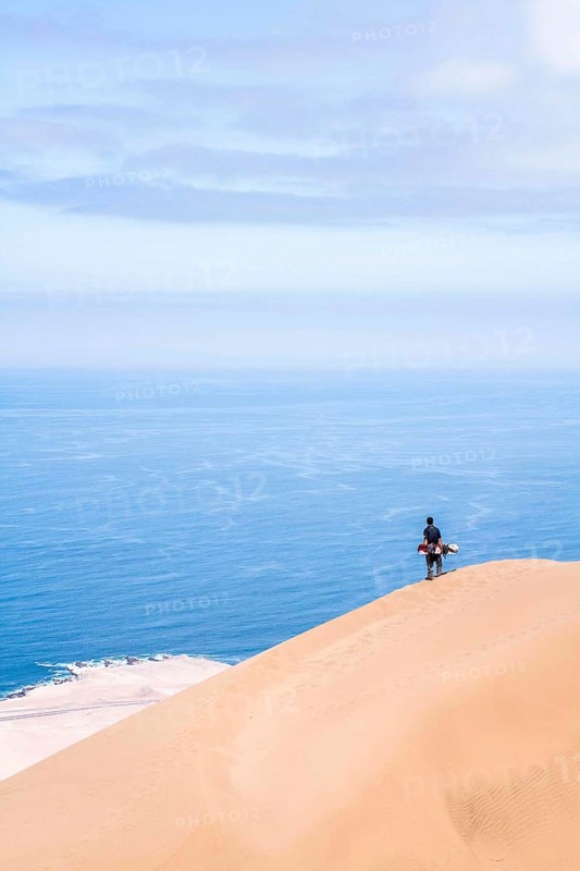 Young man looking at the view from Alto los Verdes, in Atacama Desert. Iquique, Tarapaca Region, Chile. 19.11.15