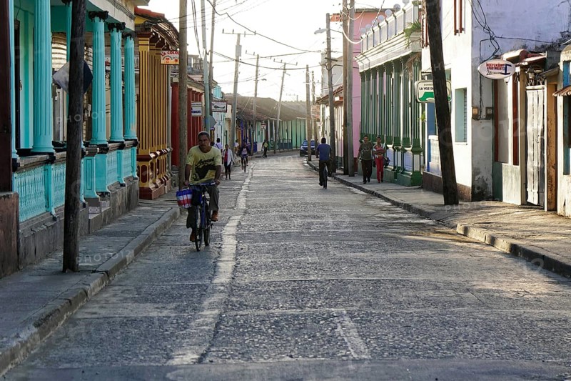 Baracoa, Cuba, Central America, narrow city street lively with cyclists and pedestrians in a colonial setting, Greater Antilles, Caribbean, America, Central America