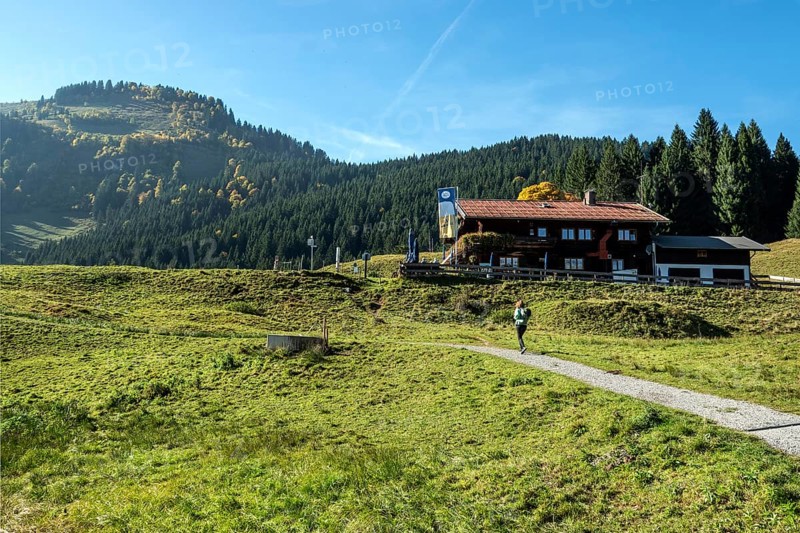Female hiker on hiking trail in front of Berggasthof Hochleite, near Schwand, Stillachtal, Oberstdorf, Oberallgäu, Allgäu, Bavaria, Germany