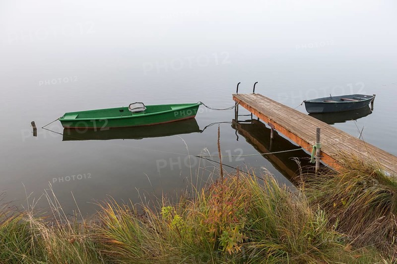 Two boats and a jetty in a misty seascape, Hopfensee, Ostallgäu, Bavaria, Germany