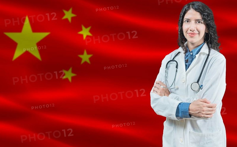 Chinese medicine and healthcare concept. Close up of doctor against China flag background