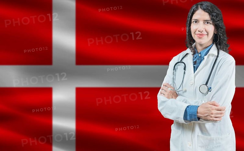 Danish medicine and healthcare concept. Close up of doctor against Denmark flag background
