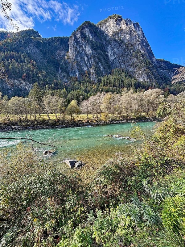 A fast-flowing river in an autumnal mountain landscape, surrounded by trees and rocks, Lienz Dolomites, Drau, Lienz, Tyrol, Austria