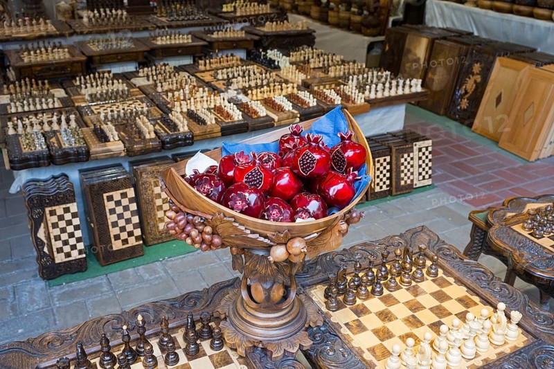 Colourful pomegranates in intricately carved wooden balls on checkerboards, Vernissage Market, Craftsmen's Market, Yerevan, Yerevan, Armenia