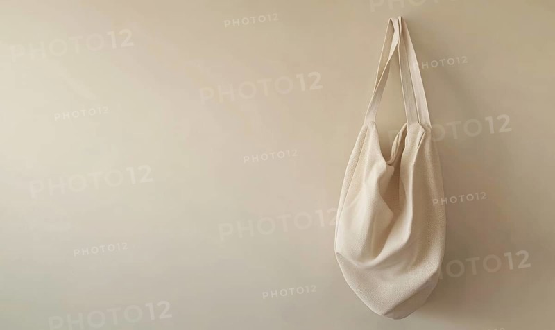A white bag hanging on a wall. The bag is large and has a pattern on it. The wall is white and the bag is the main focus of the image. AI generated