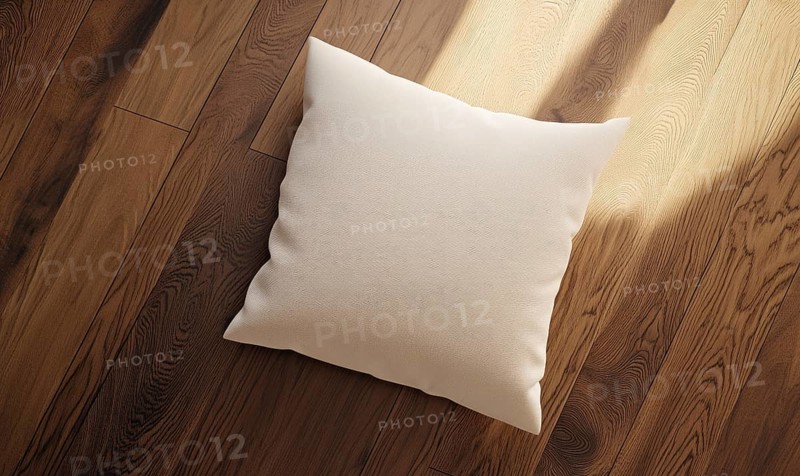 A white pillow sits on a wooden floor. The pillow is placed in the center of the image, and the floor is made of wood. The pillow appears to be a decorative item, and the wooden floor adds a warm. AI generated