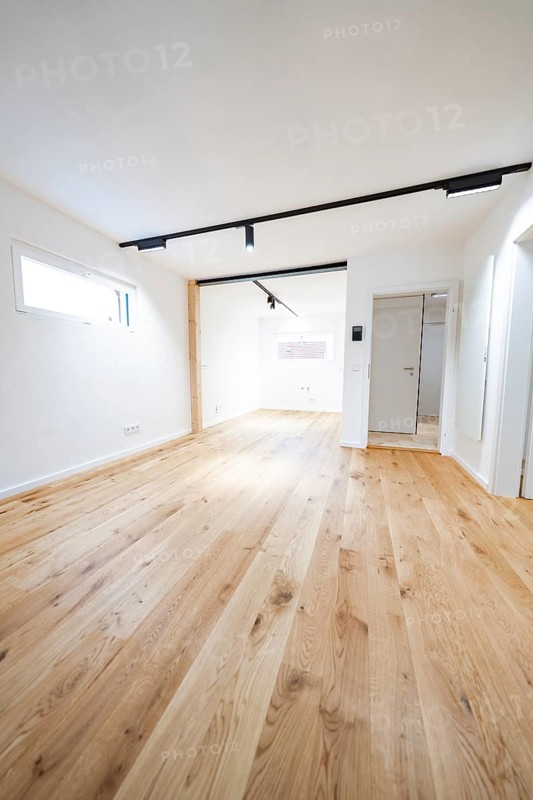 Light-flooded room with wide oak flooring and black track lights, clean lines, house renovation, energy renovation, Metzingen, Germany