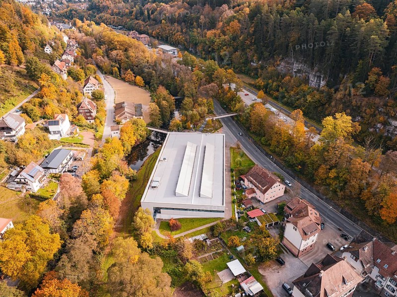Sports hall located in an autumn landscape with surrounding forest and nearby roads, Walter Lindner Sporthalle Calw, Black Forest, Germany
