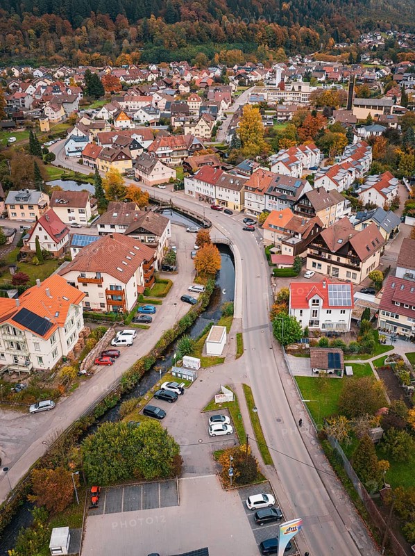 A bird's eye view of a village, showing narrow roads, lots of houses, autumn trees and cars, Calmbach, Bad Wildbad, Black Forest, Germany