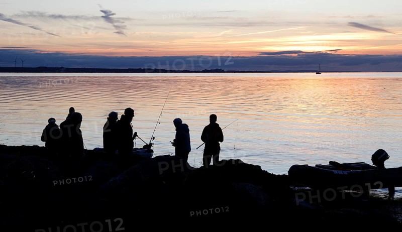 Angler on the beach during sunset, an angler docks on the shore with his inflatable boat, Fehmarn island, 18.10.2025, Fehmarn, Schleswig-Holstein, Germany
