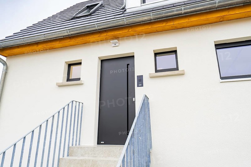 Modern house entrance with dark grey door and simple windows, staircase with metal railing, quiet bright atmosphere, house renovation, air conditioning renovation, Metzingen, Germany