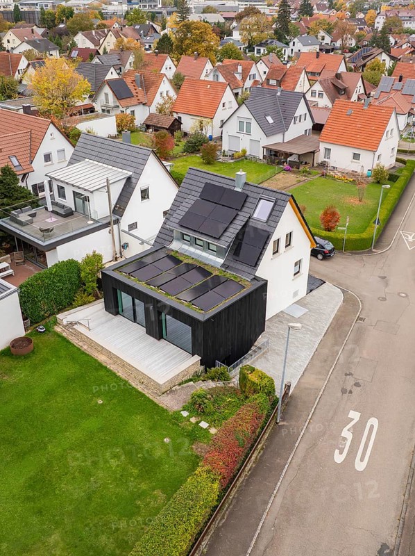 Aerial view of a house on a Tempo 30 road with PV on the roof and a green extension, with a spacious garden, house renovation, air conditioning, Metzingen, Germany