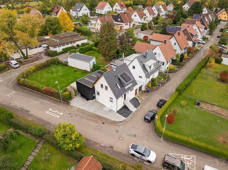 Wide angle aerial view of a quiet settlement with modernized house between well-kept gardens and autumn leaves, house renovation, climate renovation, Metzingen, Germany