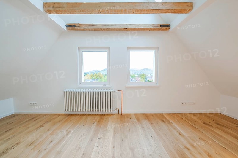 Two windows above a radiator with a view of the countryside in a quiet, bright room, house renovation, air conditioning renovation, Metzingen, Germany