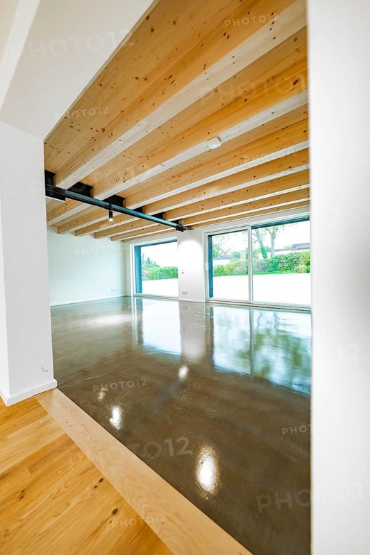 Open space with wooden ceiling, steel girders and polished concrete floor, transition from parquet area to window front, house renovation, air-conditioning renovation, Metzingen, Germany