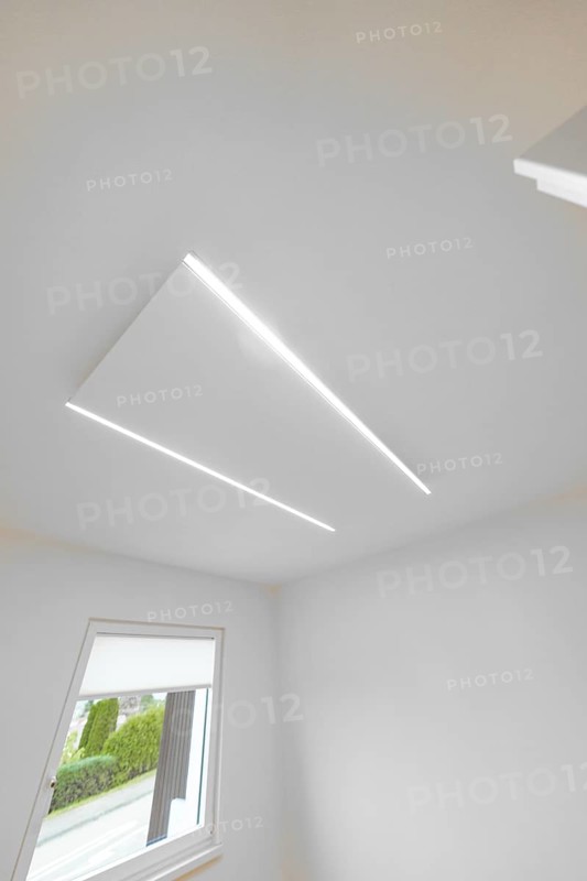 Modern white ceiling with two slim LED lines, geometric light detail near window, house renovation, climate renovation, Metzingen, Germany