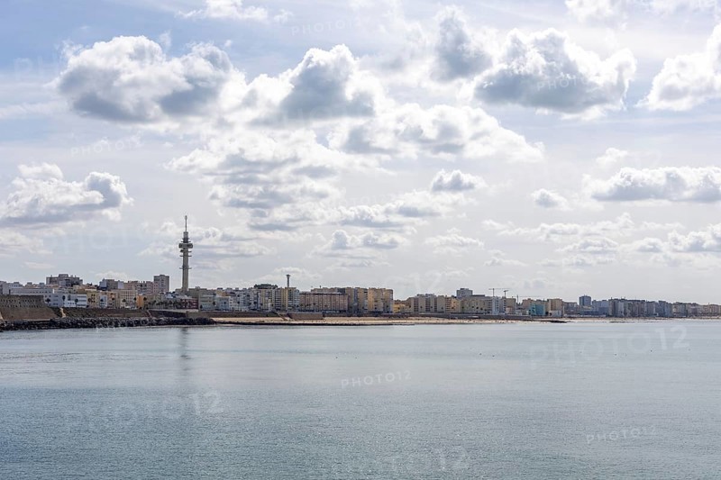 An old historic town. The skyline along the city beach and promenade shows its former glory. Cadiz television tower is in the background, Andalusia, Atlantic, Spain