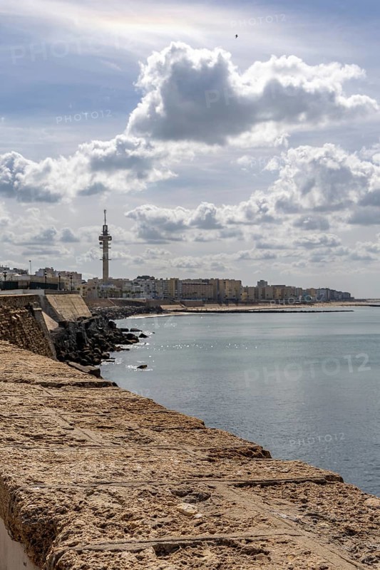 An old historic town. The skyline along the city beach and promenade shows its former glory. Cadiz Cathedral is in the background, Andalusia, Atlantic, Spain