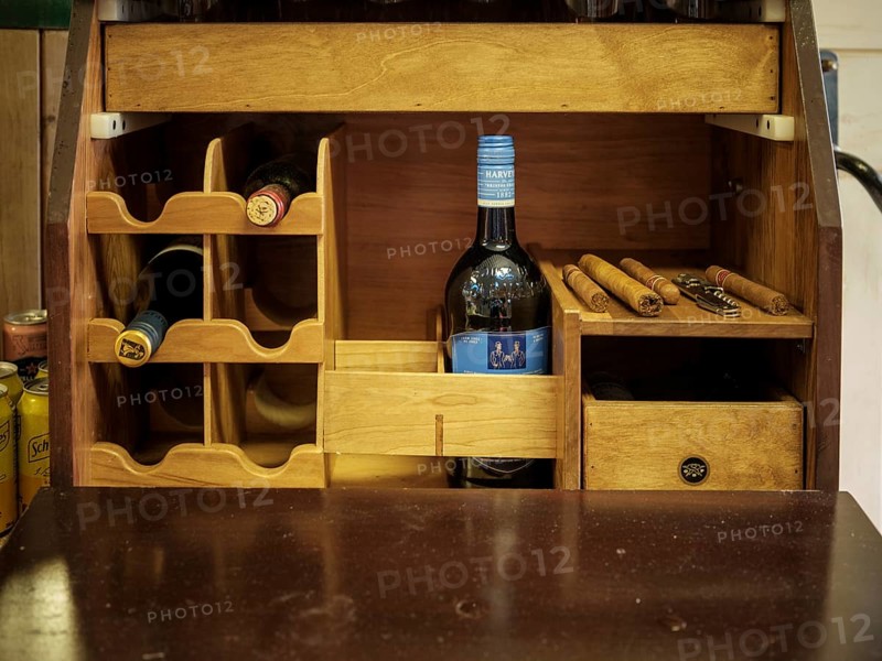 A fox hunting tack trunk with individual cigars, a bottle of sherry and an opener