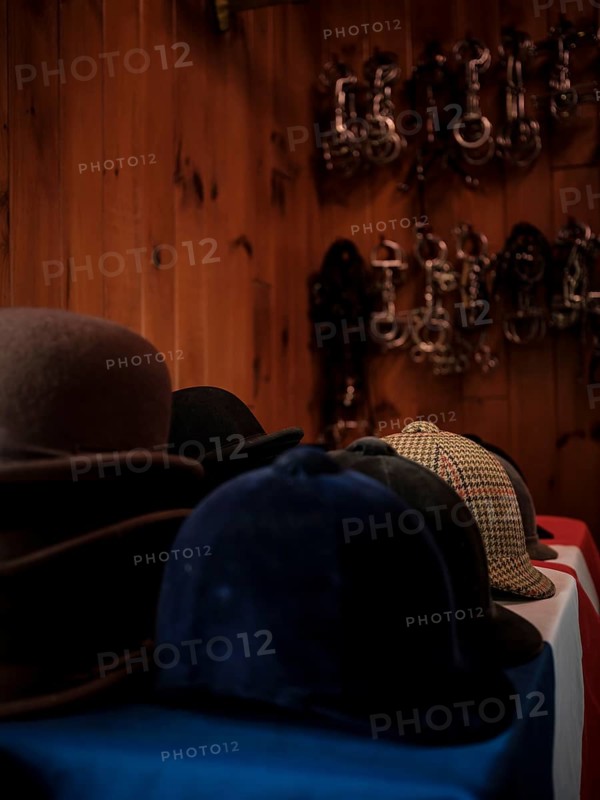 The tack room at the Toronto North York Hunt Club displaying a number of riding helmets, hats and a selection of horse bits hanging on the wall, on August 26, 2025 in Mulmer, Ontario, Canada