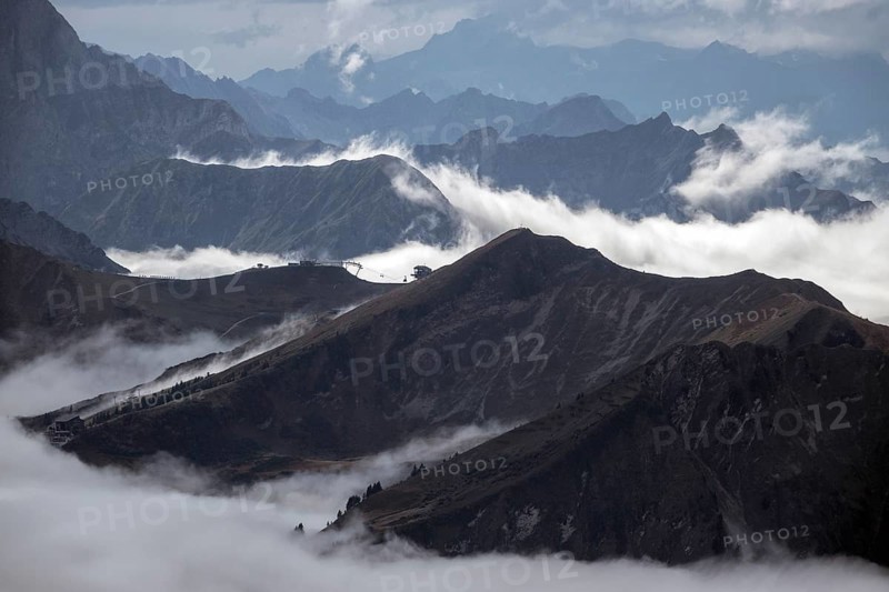 View from the Nebelhorn summit of the Allgäu Alps, in the middle of Fellhorn Horn with summit station, mountains rising from fog in the valley, Oberstdorf, Oberallgäu, Allgäu, Bavaria, Germany