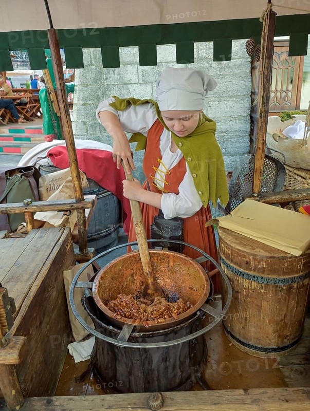 Disguised woman offering roasted almonds, Olde Hansa Restaurant, Old Town, Tallinn, Estonia