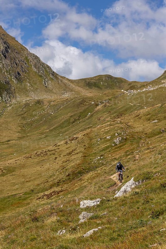 Mountain biker on the trail downhill at Passo del Sole, Olivone, Tessin, Switzerland