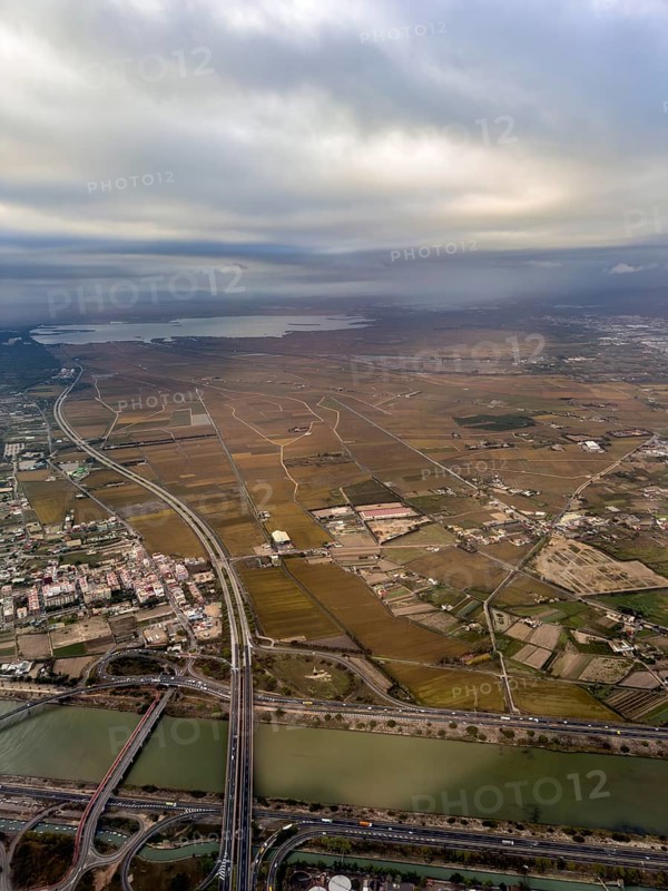 Turia flood canal with CV-500 road bridges, Albufera lagoon behind, aerial view, Valencia, Spain