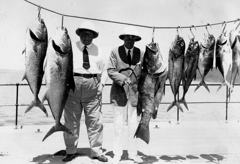 Two men pose with various captured groupers and mackerel, around 1930s, Florida, USA