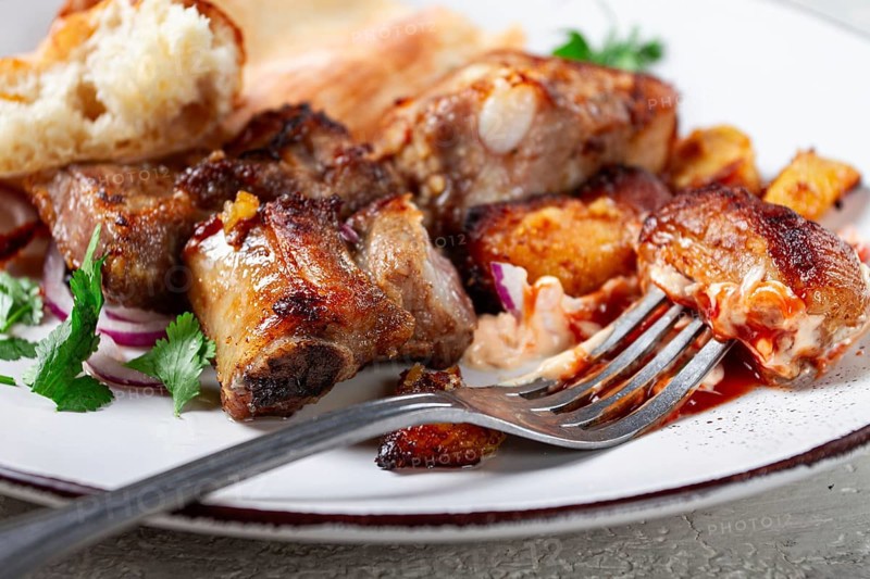 A plate with leftover pork kebab, with bread, on a white plate, close-up, there are no people