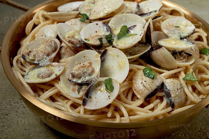 Spaghetti with vongole clams, in cream sauce, carbonara, in a brass pan, homemade, top view, no people