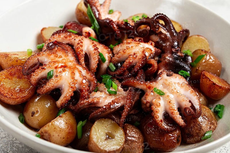 Baby grilled octopus with golden baked potatoes and fresh herbs, Maltese cuisine, homemade, no people