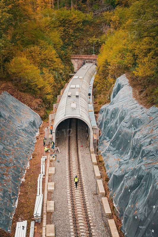 Railway line with partial tunnel in autumn surroundings with construction workers, Hermann-Hesse-Bahn construction site, Calw, Germany
