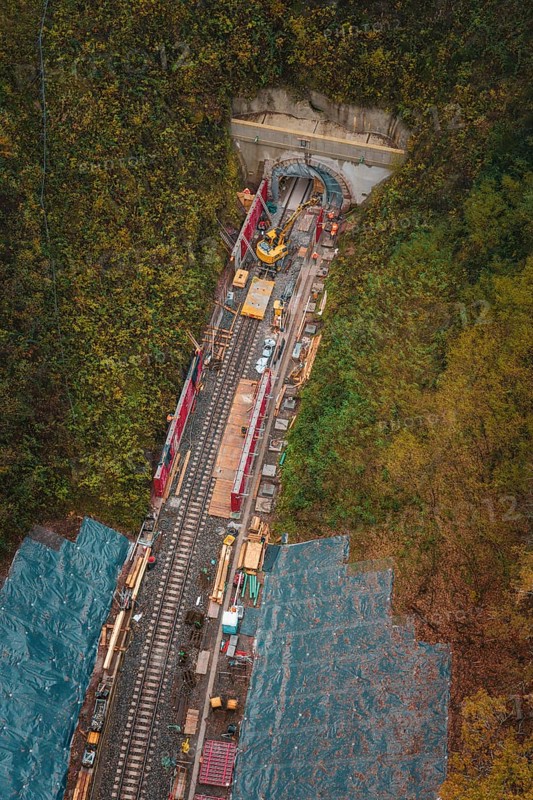 Aerial view of a rail building with tunnel opening and construction work in autumn forest, Hermann-Hesse-Bahn construction site, Calw, Germany