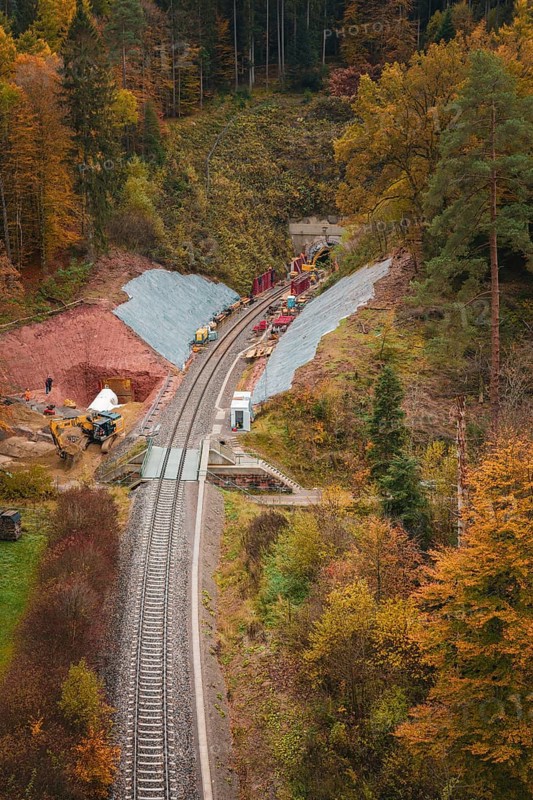 A railway line with construction and tunnel work, surrounded by autumn forests, Hermann-Hesse-Bahn construction site, Calw, Germany