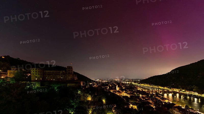 Nocturnal sky with aurora borealis over Heidelberg. Heidelberg Castle on the left, the Neckar river on the right. Rhein-Neckar District, Baden-Württemberg, Germany