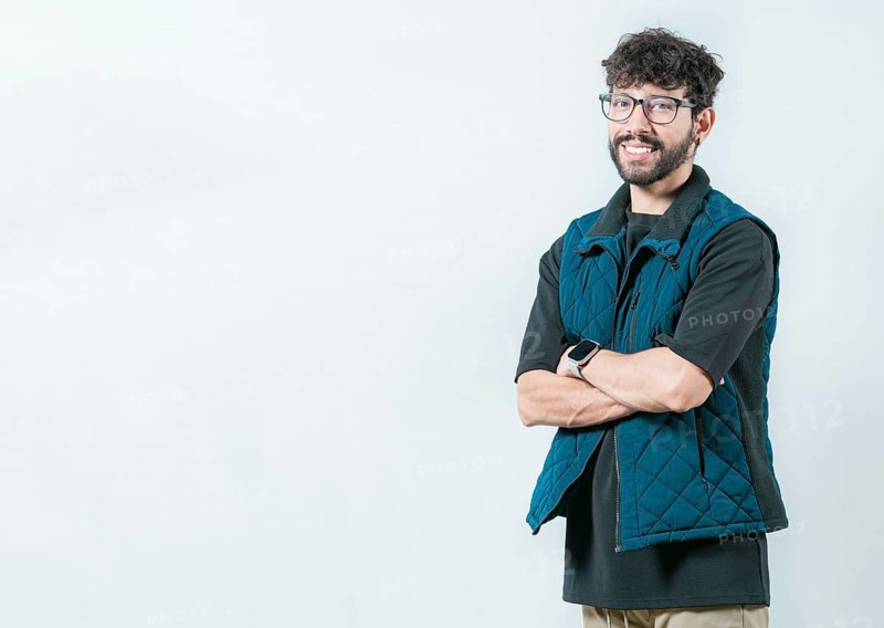 Smiling and handsome guy with glasses holding arms crossed isolated. Portrait of cool and handsome casual man with glasses and crossed arms