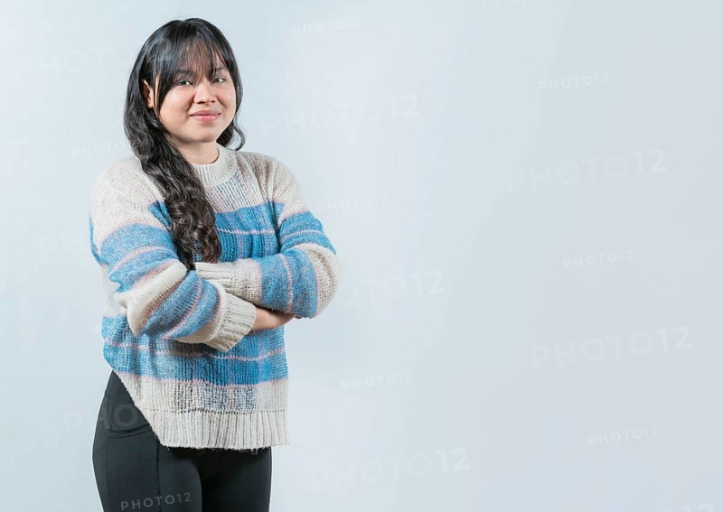Attractive young Asian woman with arms crossed isolated. Portrait of beautiful and smiling Asian woman on white background