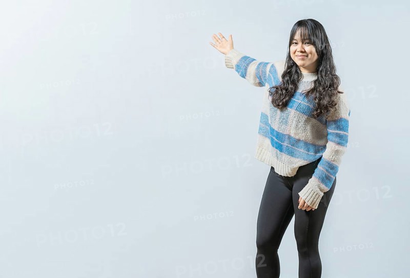 Happy girl welcoming you on isolated bakground. Smiling young woman presenting something, isolated
