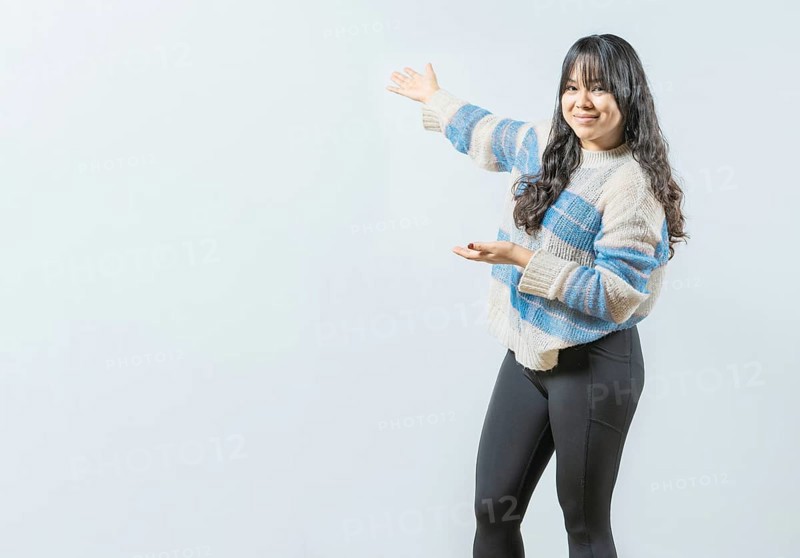 Smiling asian woman presenting something, isolated. Happy girl welcoming you on isolated bakground