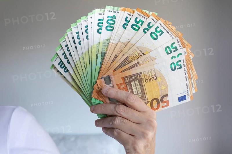 Human hand with several 50 and 100 euro banknotes