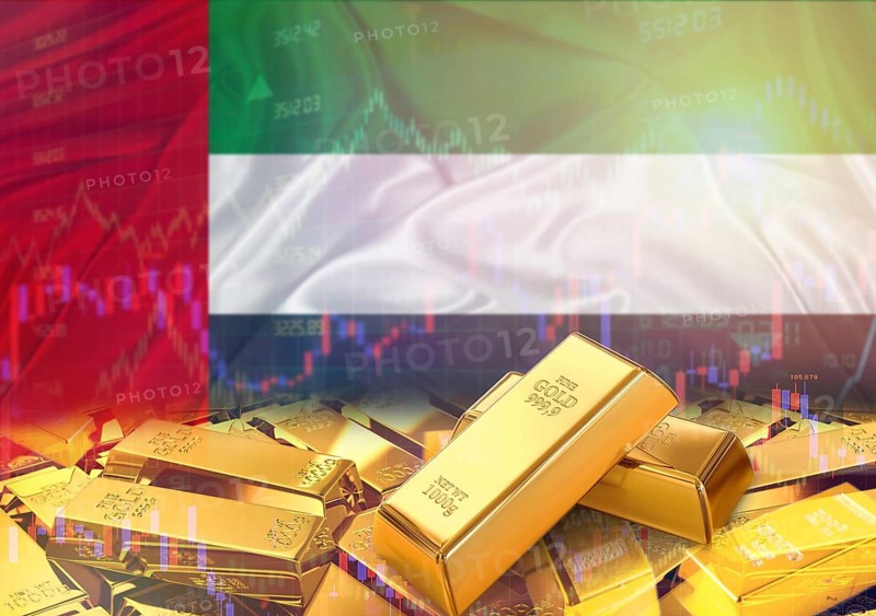 Gold bars on United Arab Emirates flag in background. Gold bars stacked on Emirati flag. Concept of United Arab Emirates gold reserves