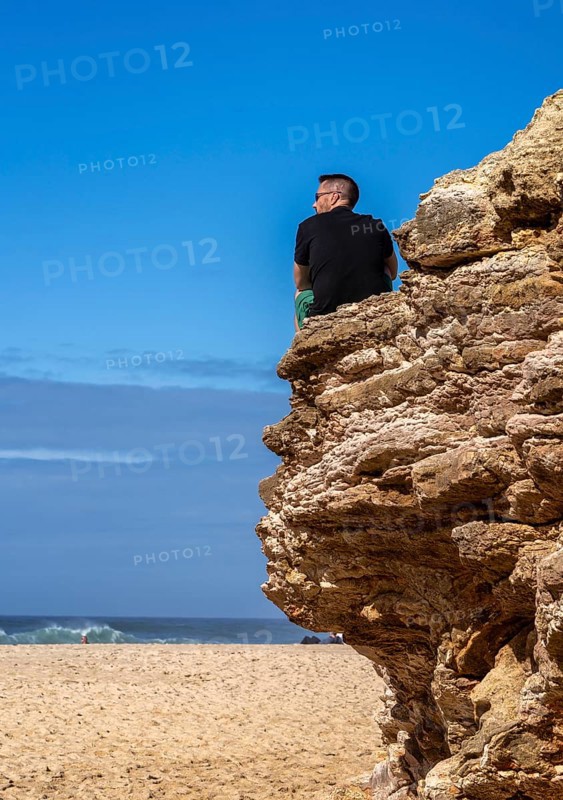 Tourists watch the waves of the Atlantic on the rocky plateau of Sito, also known as Forte São Miguel, a surfing paradise with monster waves in the months of November to February, Nazaré, Portugal
