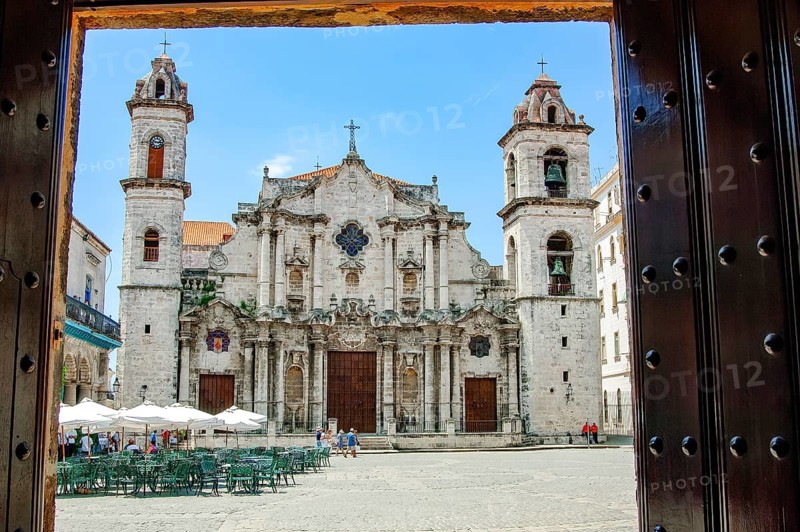View from through portal Entrance of Museo de Arte Colonial Casa de Don Luis Chacón across Plaza de la Catedral Cathedral Square of the Cathedral of the Virgin Mary of the Immaculate Conception Catedral de la Virgen María de la Concepción Inmaculada de La Habana in Old Havana, La Habana Vieja, Havana, Cuba
