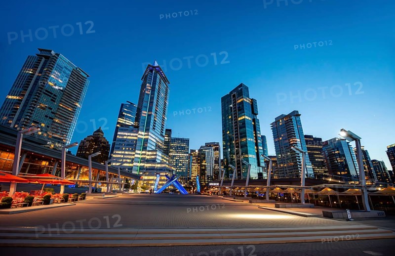 Illuminated skyscrapers on the promenade in the evening, Olympic Cauldron Statue, Jack Poole Plaza Square, Blue Hour, Coal Harbour, Vancouver, British Columbia, Canada