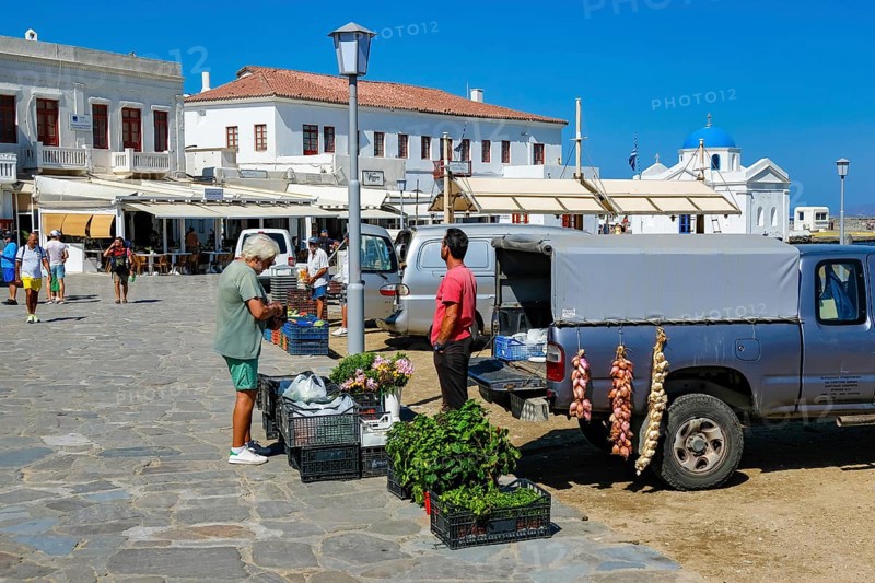 Mykonos, Cyclades, Greece - Vegetable seller sells vegetables, herbs and flowers directly from his van to tourists and locals at the port, old town of Mykonos Town, Mykonos Chora. Mykonos is part of the Cyclades archipelago