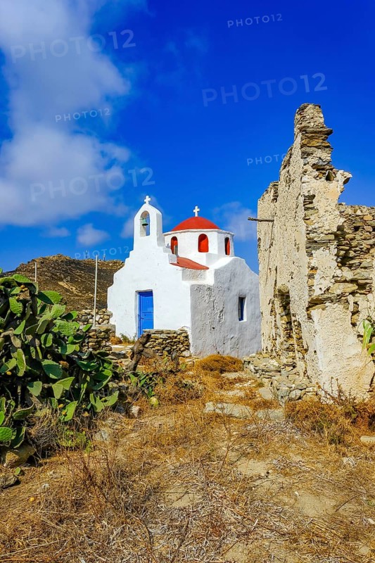 Ano Mera, Mykonos, Cyclades, Greece - Small church from the 18th century on the site of the Gyzi ruins, 13th century castle ruins by the Venetian Gyzi family, right next to the Paleokastro monastery in the interior of the island just outside Ano Mera, is now a tourist attraction much visited by tourists. Typical fig cacti in front