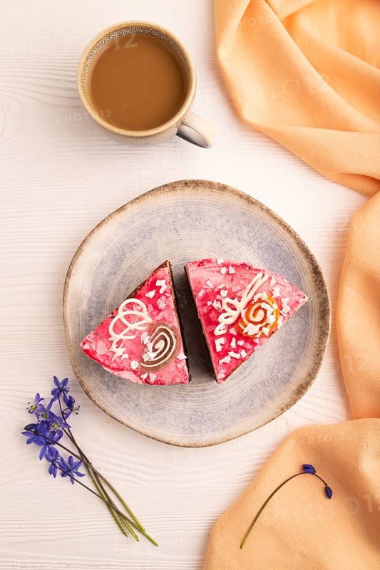 Chocolate cake on white wooden background and orange linen textile, cup of coffee, top view, flat lay, close up