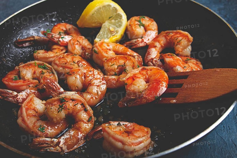 Fried tiger prawns, jumbo, in garlic sauce, in butter, with herbs, in a frying pan, homemade, no people