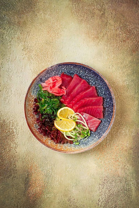 Tuna sashimi with daikon and wakame salad, pickled ginger, in a bowl